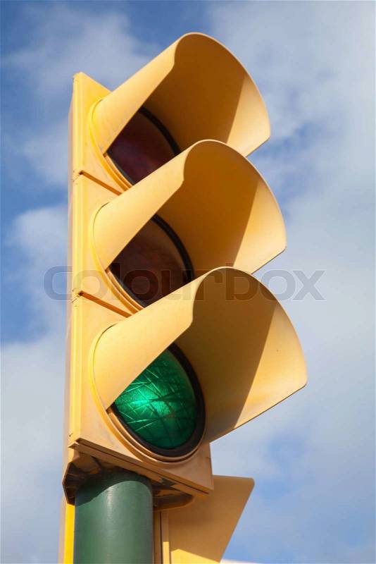 Yellow traffic light shows green allowed signal, stock photo