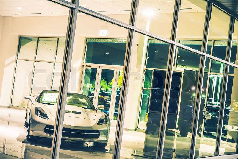 Luxury Sporty Car For Sale Inside Dealer Showroom at Night. Car Sales Concept, stock photo