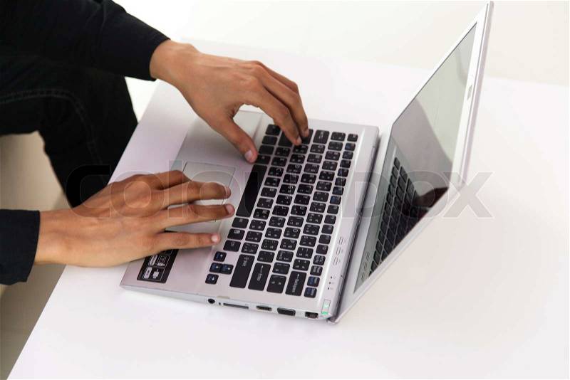 Male hands typing on laptop keyboard, stock photo