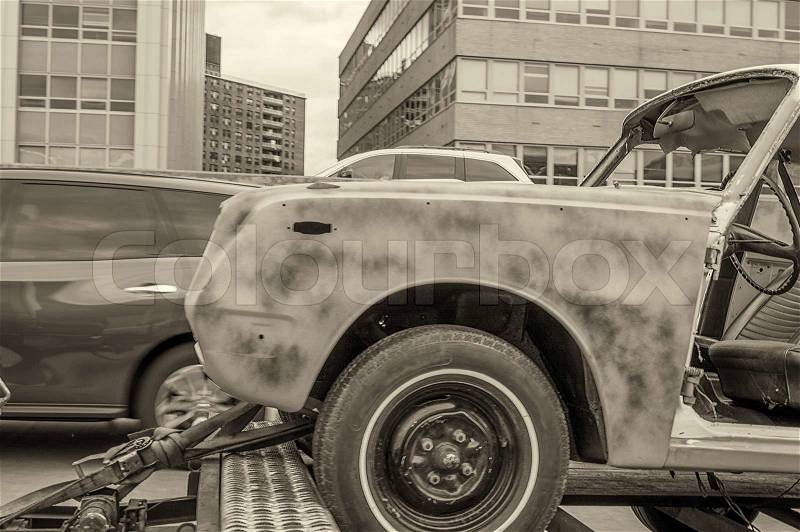 Damaged car on a tow truck after a street accident, stock photo