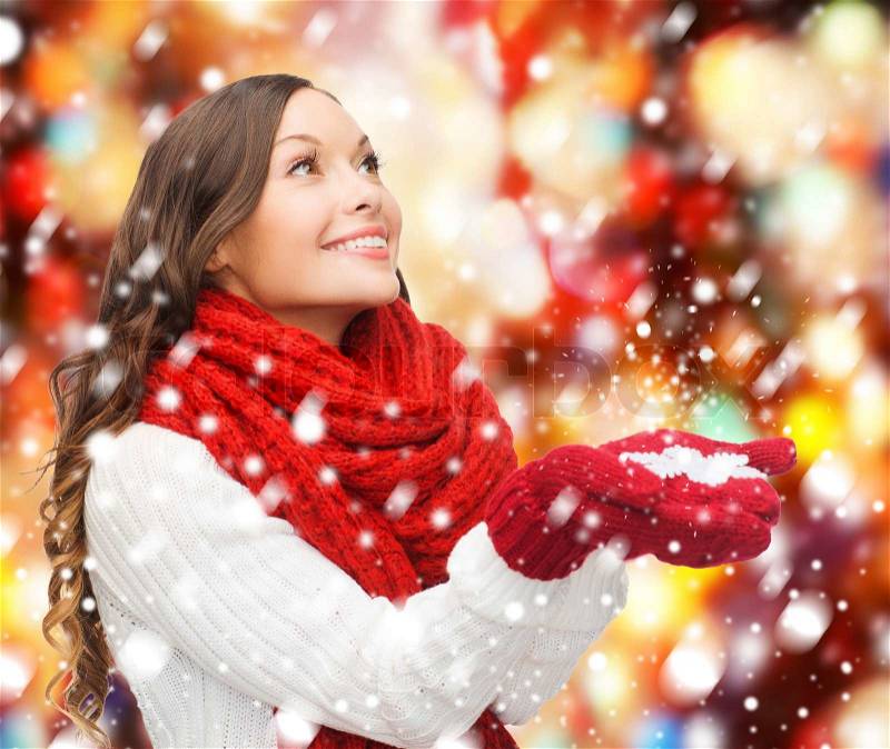 Winter, people, happiness concept - woman in scarf and gloves with big snowflake, stock photo