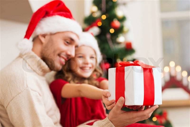 Holidays, christmas, family and happiness concept - close up of father and daughter with gift box, stock photo