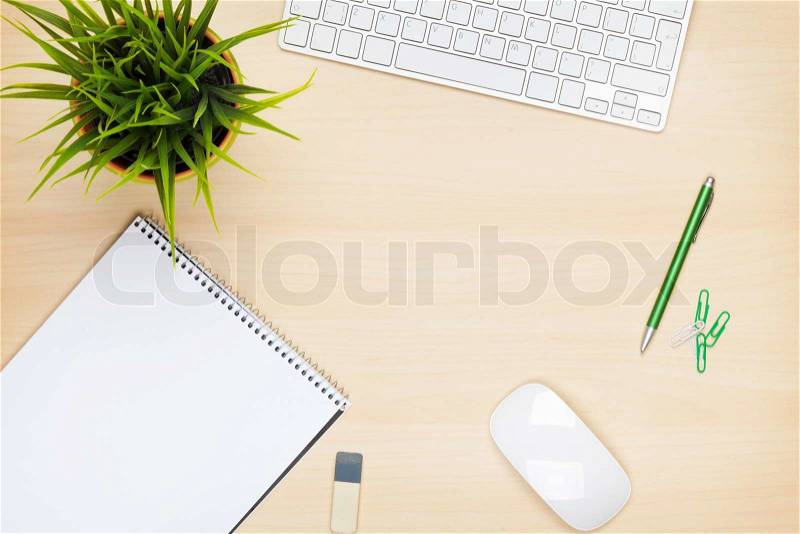 Office table with notepad, computer and flower. View from above with copy space, stock photo