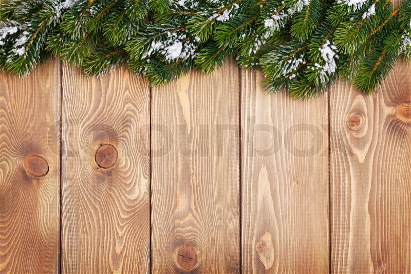 Christmas fir tree with snow on rustic wooden board with copy space, stock photo