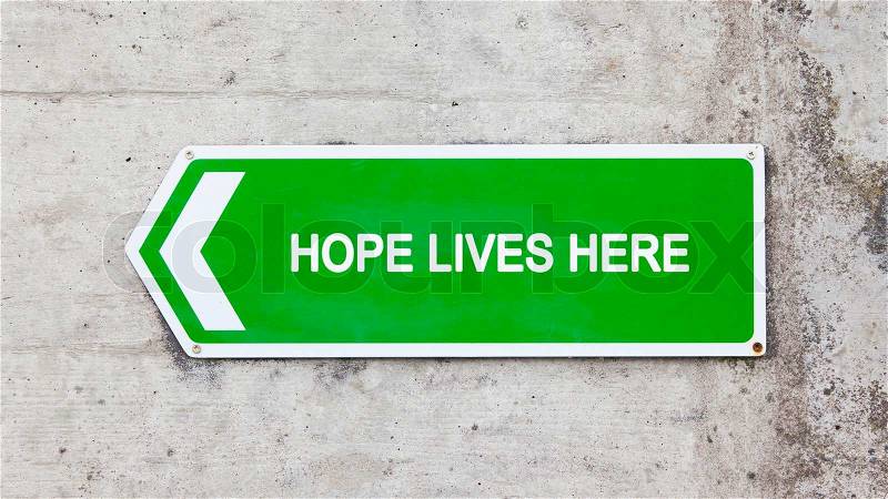 Green sign on a concrete wall - Hope lives here, stock photo