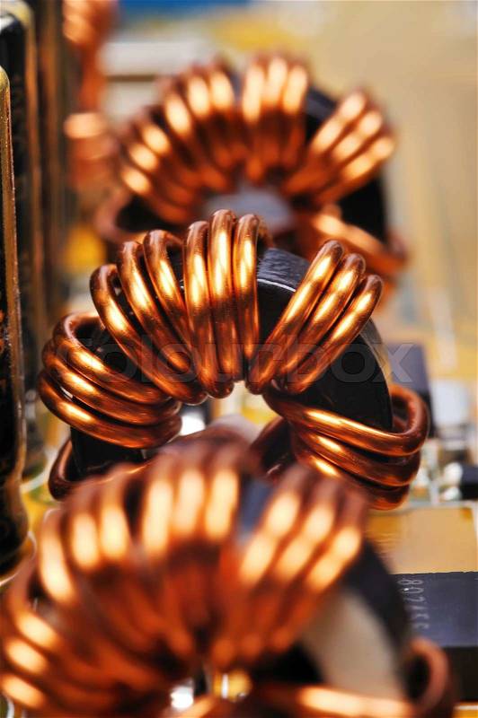 Three ferrite rings on circuit board, close up, stock photo