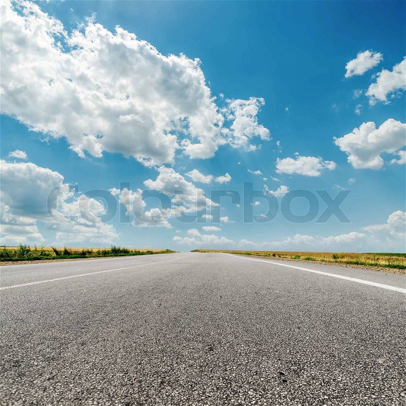Asphalt road to horizon and clouds over it, stock photo
