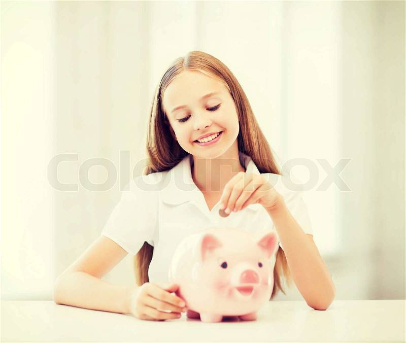 Education, school and money saving concept - child putting coins into piggy bank, stock photo