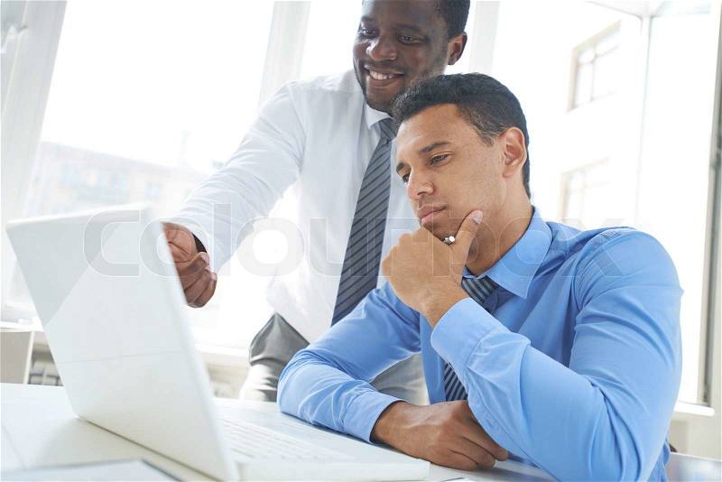 African-american businessman explaining new project to his colleague in office, stock photo