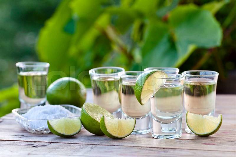 Gold tequila with salt and lime on old wooden table, stock photo