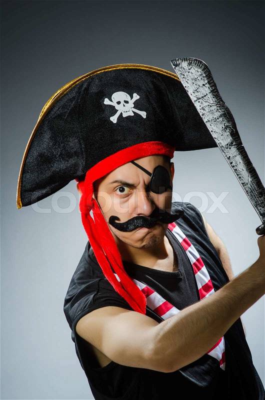 Funny pirate in the dark studio, stock photo