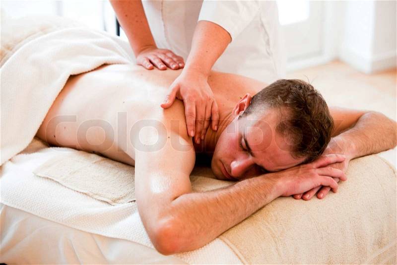 A male caucasian in a wellness spa getting massage, stock photo