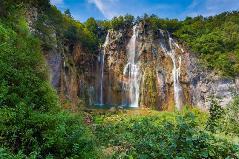 Landscape of a beautiful rock with a waterfall under the blue sky. Plitvice Lakes National Park is the oldest national park in Southeast Europe and the largest national park in Croatia, stock photo