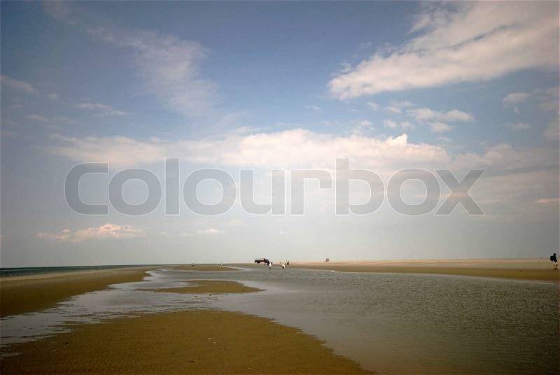 People walking in Danish desert on Koresand. Wadden Sea low tide landscape, stock photo