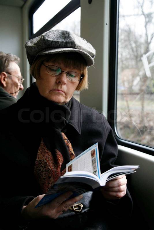 Tourist reading i guide book - local train Germany, stock photo