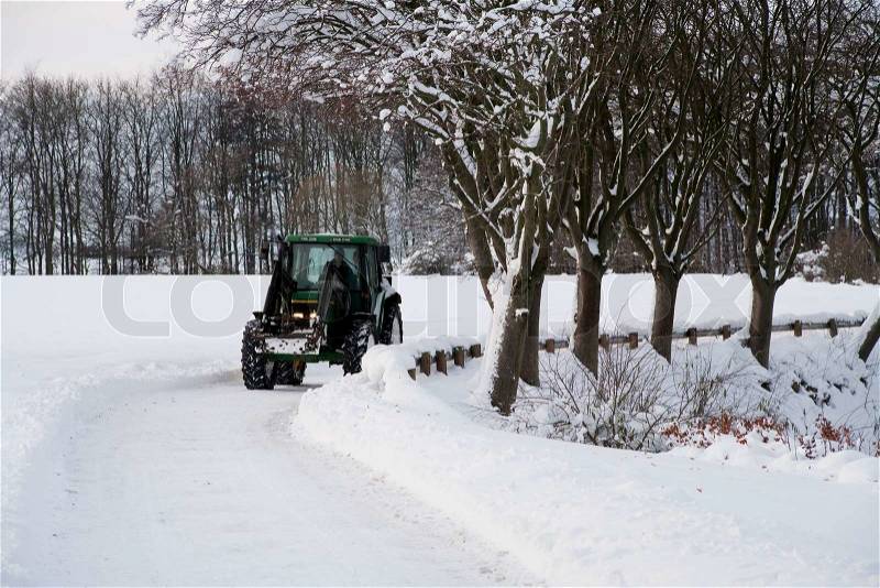 Tractor on a snow covered road, stock photo
