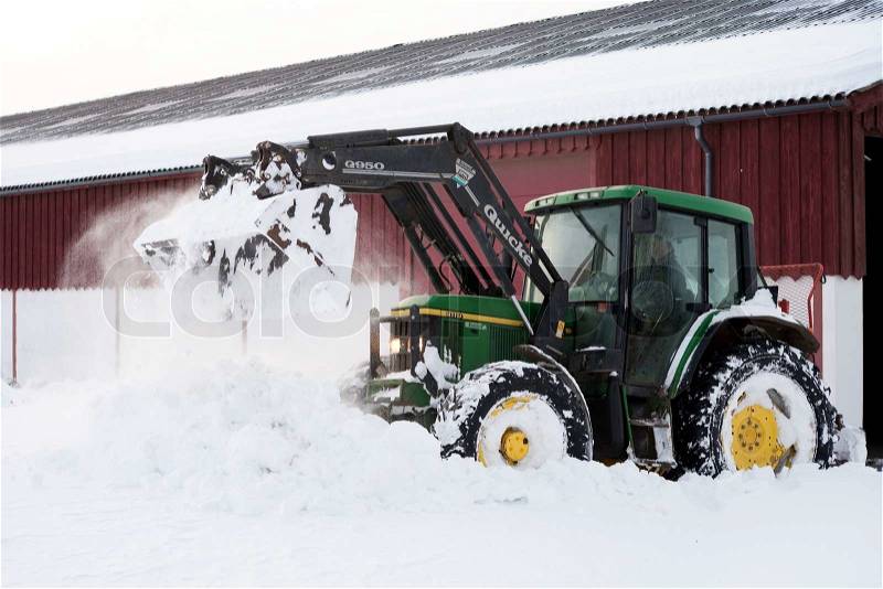 A tractor clearing the road covered with snow, stock photo