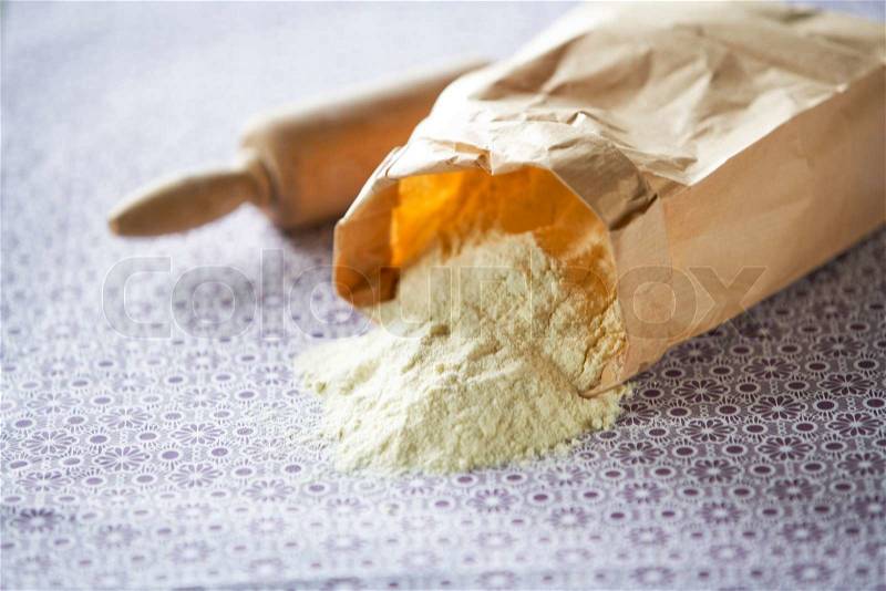 Flour in a paper bag and rolling pin, stock photo