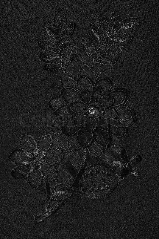 Black flower lace pattern on black fabric, stock photo
