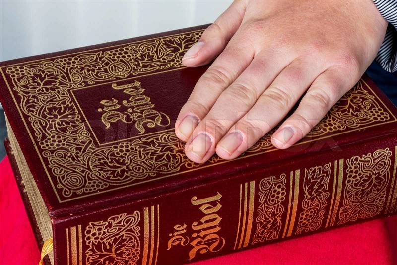 A woman says as a witness in court in a lawsuit. is sworn in and swears on the bible, stock photo