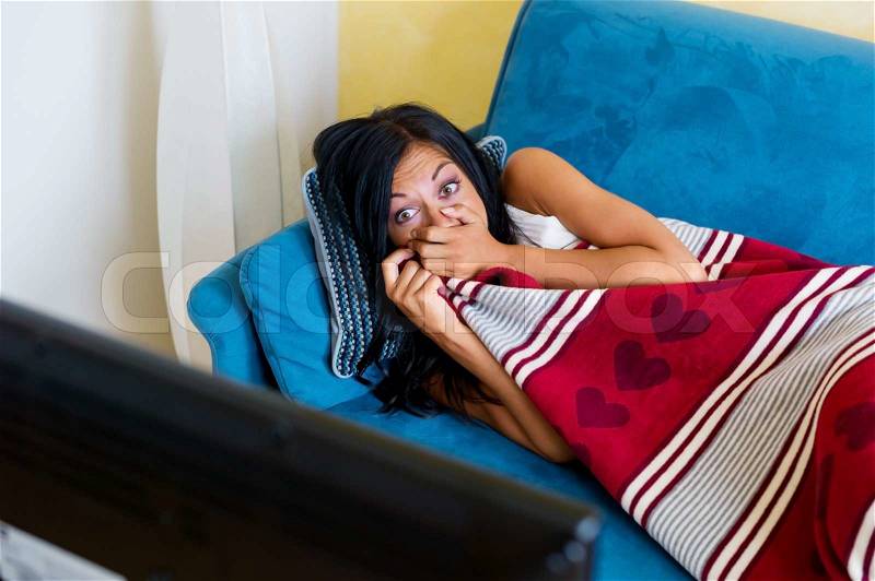 A young woman looks a sad movie on tv, stock photo