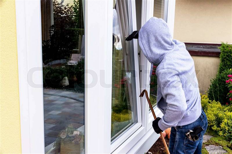 A burglar tried to break at an open window with a crowbar, stock photo