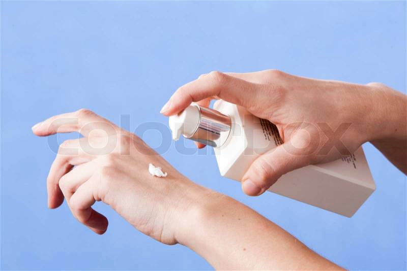 Applying lotion on hands, stock photo