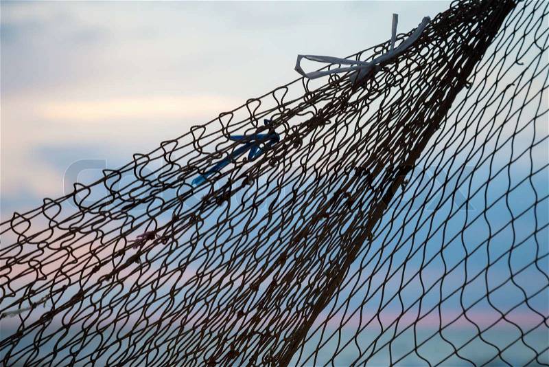 Fishing net silhouette above morning sky background, stock photo