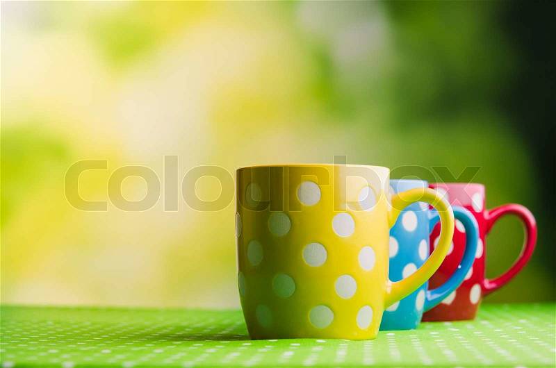 Colored coffee cups on table, stock photo