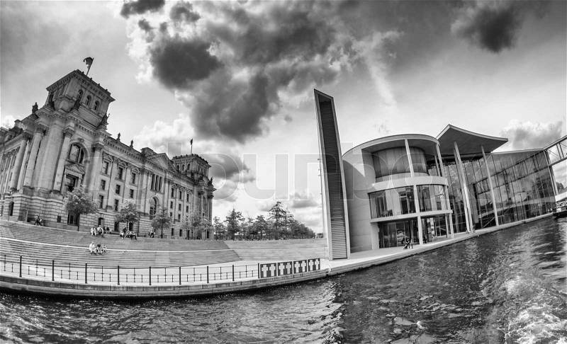 BERLIN - MAY 27, 2012: Tourists visit the modern buildings in Bundestag area along Spree river. The city has more than 26 million overnight stays every year, stock photo