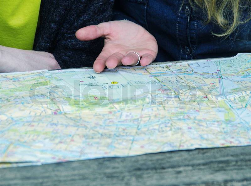 Couple checking city map outdoor. Detail on hands, stock photo