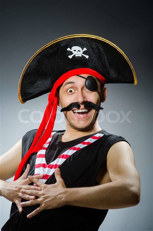 Funny pirate in the dark studio, stock photo