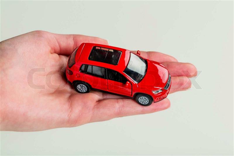 A hand holding the model of a car. symbol photo for car purchase, stock photo
