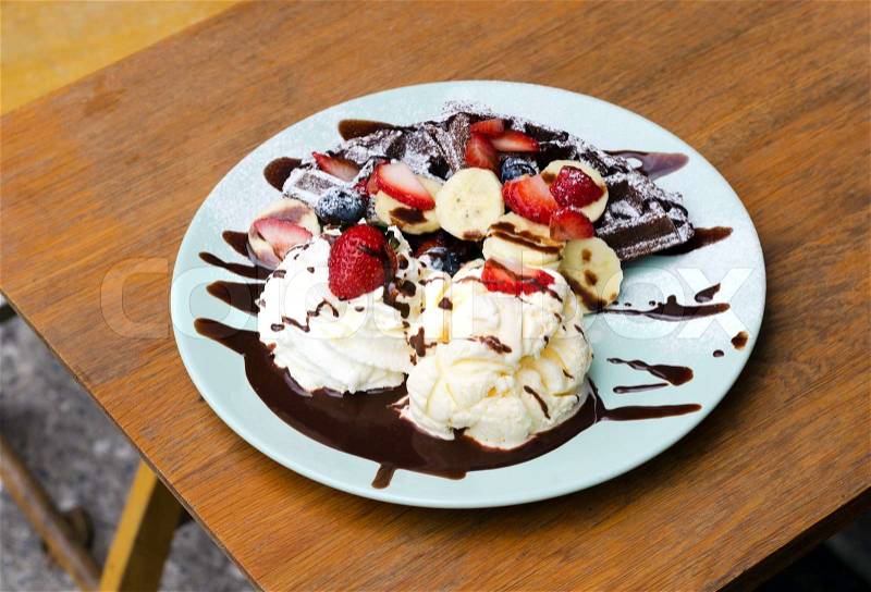 Ice cream, banana, strawberry, raspberry, chocolate waffles with chocolate sauce , stock photo