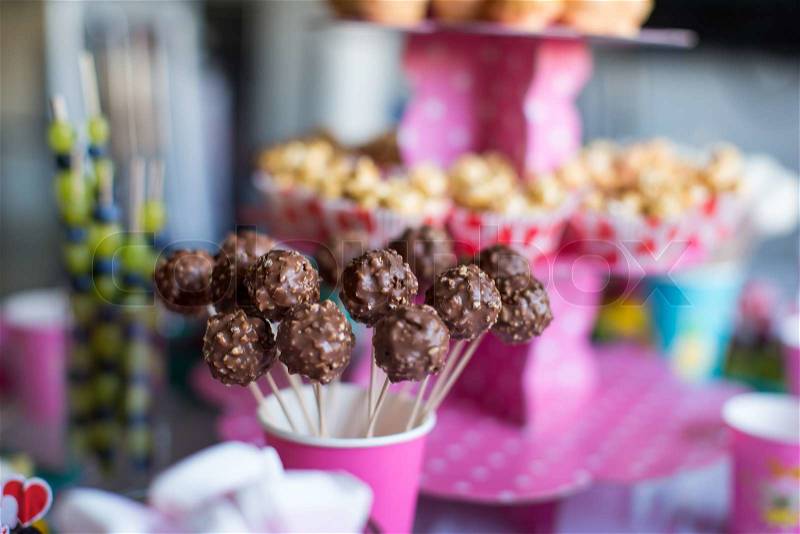 Chocolate cakepops on holiday dessert table at kid birthday party, stock photo