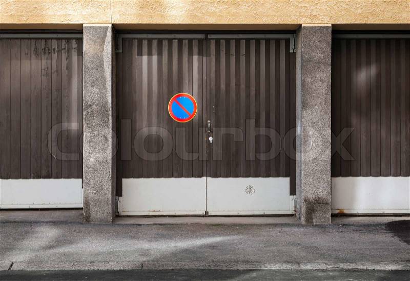 Brown metal garage gates with no parking road sign, stock photo