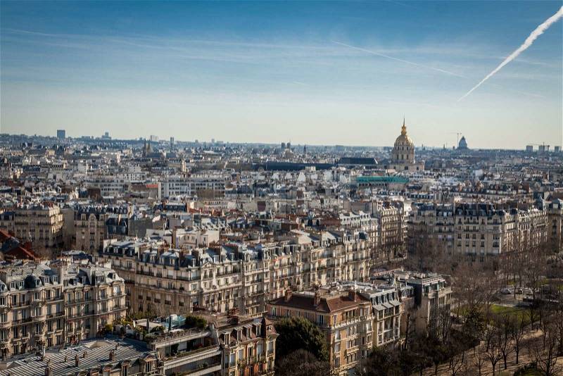 View over the rooftops of Paris, France with its streets of historical buildings to a distant skyline under a blue sky, travel concept, stock photo