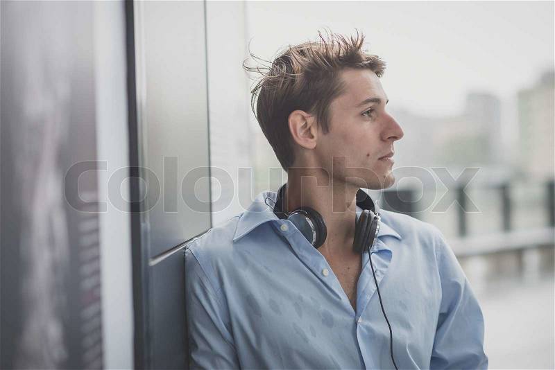 Young model hansome blonde man with headphones in the city, stock photo