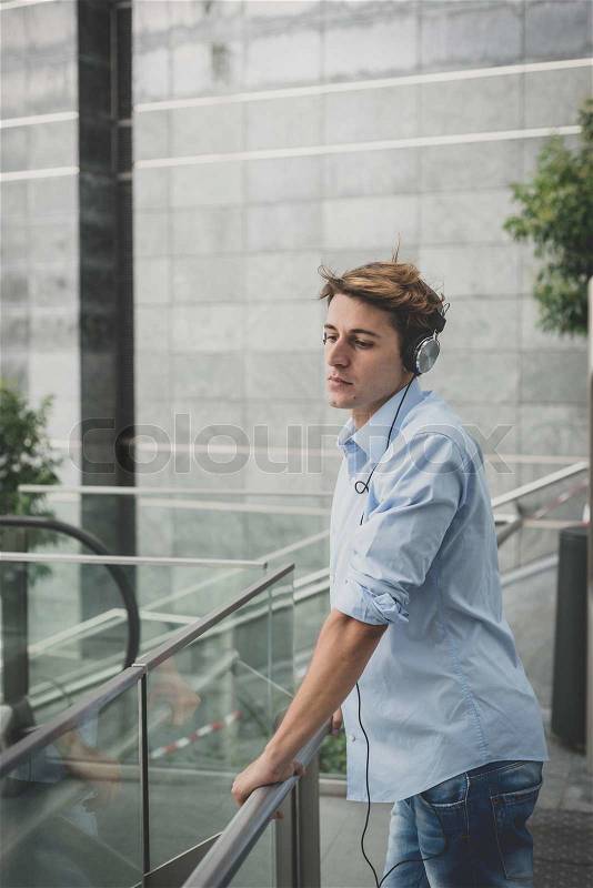 Young model hansome blonde man with headphones in the city, stock photo