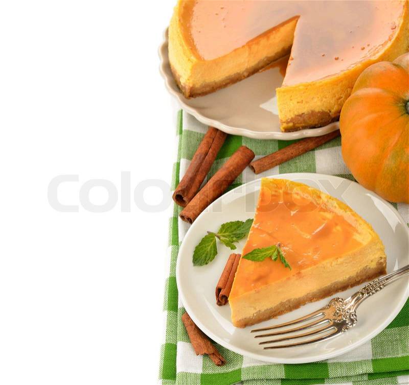 Pumpkin cheesecake with caramel icing on white background, stock photo