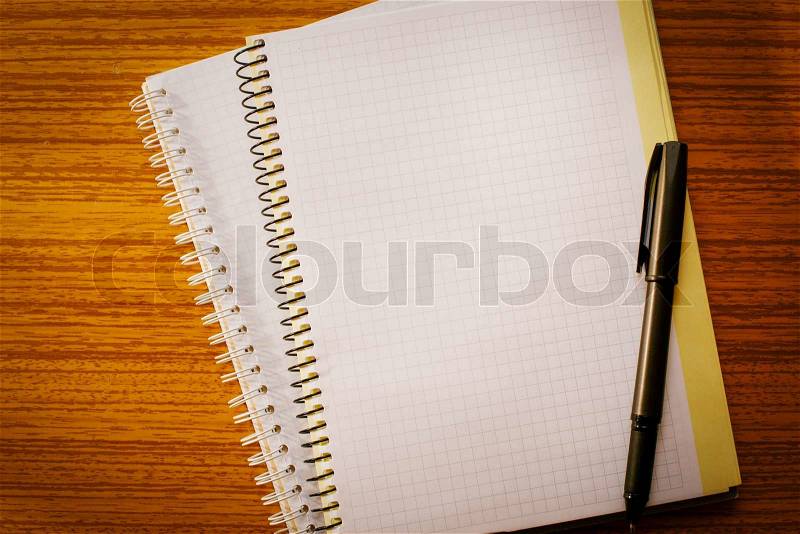 Open notebook on the table and ballpoint pen for business planning, stock photo