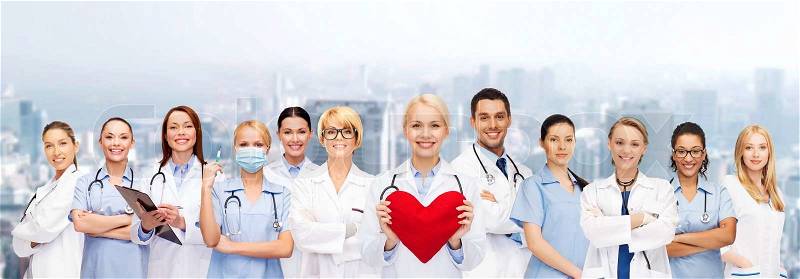 Healthcare and medicine concept - smiling doctors and nurses with red heart, stock photo