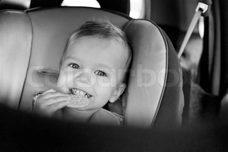 Happy Toddler boy in the car eating cookies ( black and white ), stock photo