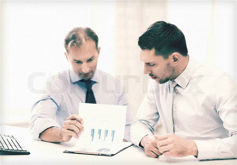 Businessmen with notebook discussing graphs on meeting, stock photo