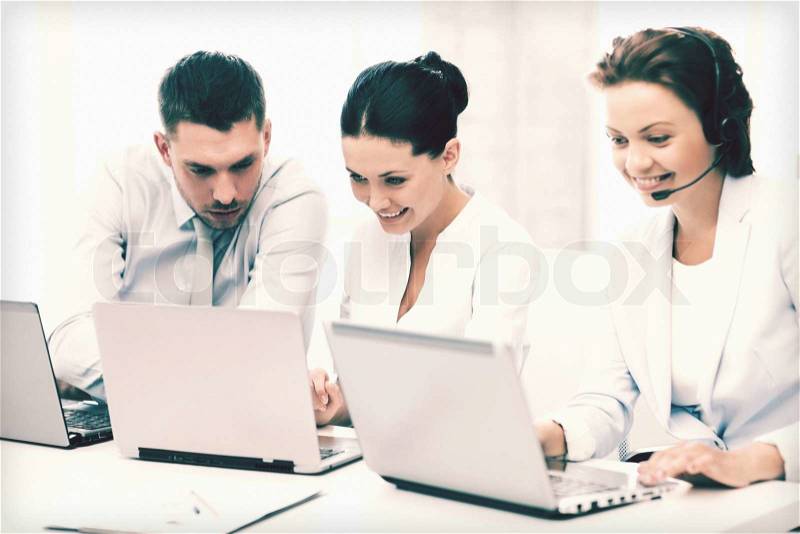 Picture of group of people working with laptops in office, stock photo