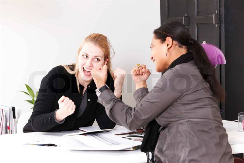 Two female work colleagues happy over a good work results, stock photo