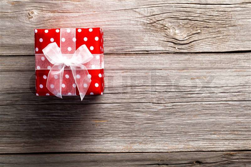 Red gift box, polka dots, on wood background, stock photo