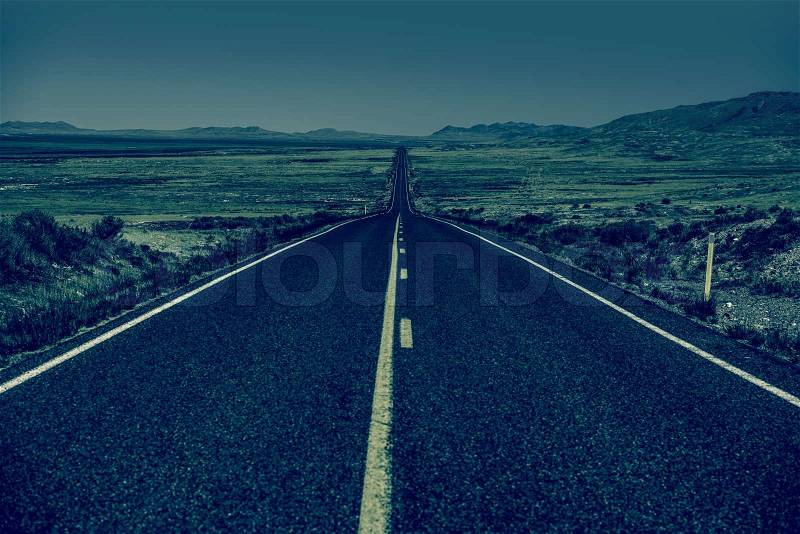 Down the Road. Straight Desert Highway in Bluish Color Grading. Straight Road to Nowhere, stock photo