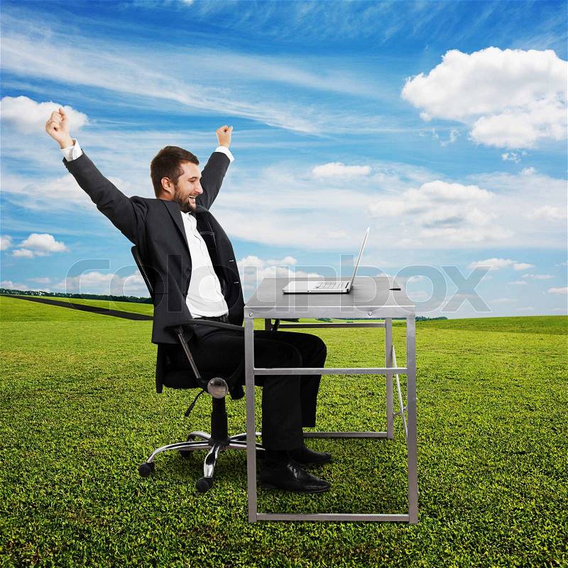 Successful businessman raising hands up, looking at laptop and laughing. photo at outdoor, stock photo