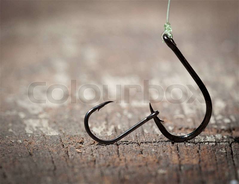 Fish hook on wood background, stock photo